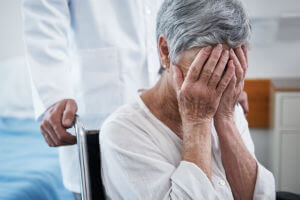 Elderly woman covering face