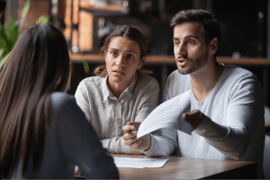 upset-looking couple talking to attorney