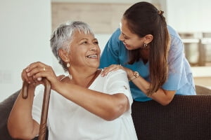 An elderly woman being visited by an assisted living caregiver