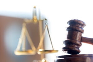 image of justice scales and gavel in courtroom.