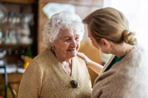 image of an elderly female dementia patient with a caregiver